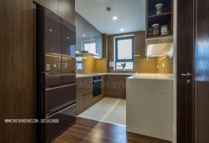 Phòng bếp thu hút ánh nhìn bởi mẫu tủ bếp gỗ công nghiệp và sự kết hợp giữa màu sắc của tủ cùng với kính màu ốp bếp màu vàng.